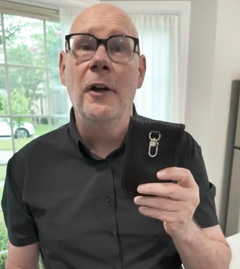 Person testing a Totyn Faraday pouch by placing car key inside to block signal.