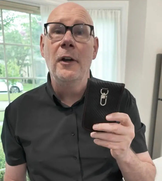 Person testing a Totyn Faraday pouch by placing car key inside to block signal.