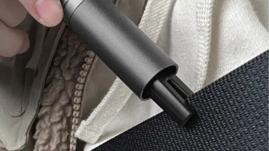 Person using a built-in stainless steel cutter to cut a seatbelt, with text indicating an unimpeded emergency escape feature.