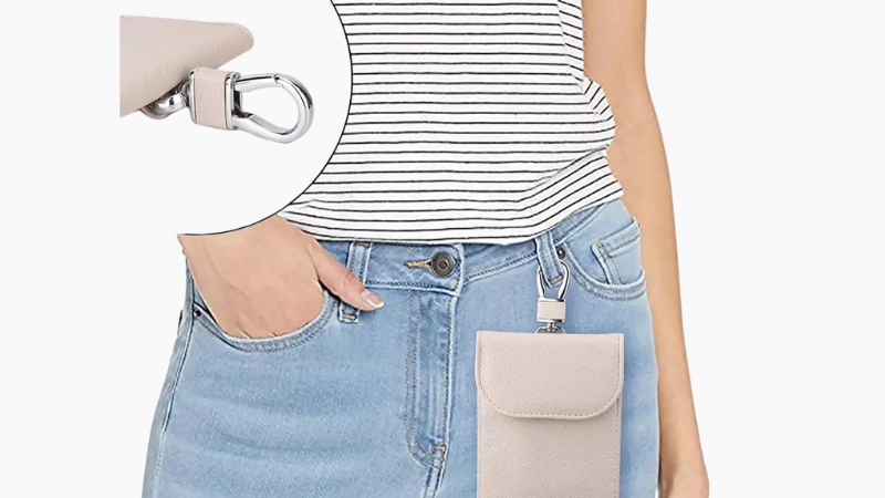 Person wearing a beige faraday bag with a striped shirt and light blue jeans on a white background