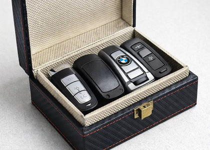 Set of car keys in a  faraday box on a light gray background