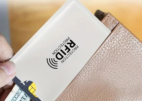 Person holding a card with RFID protection label over a wallet.